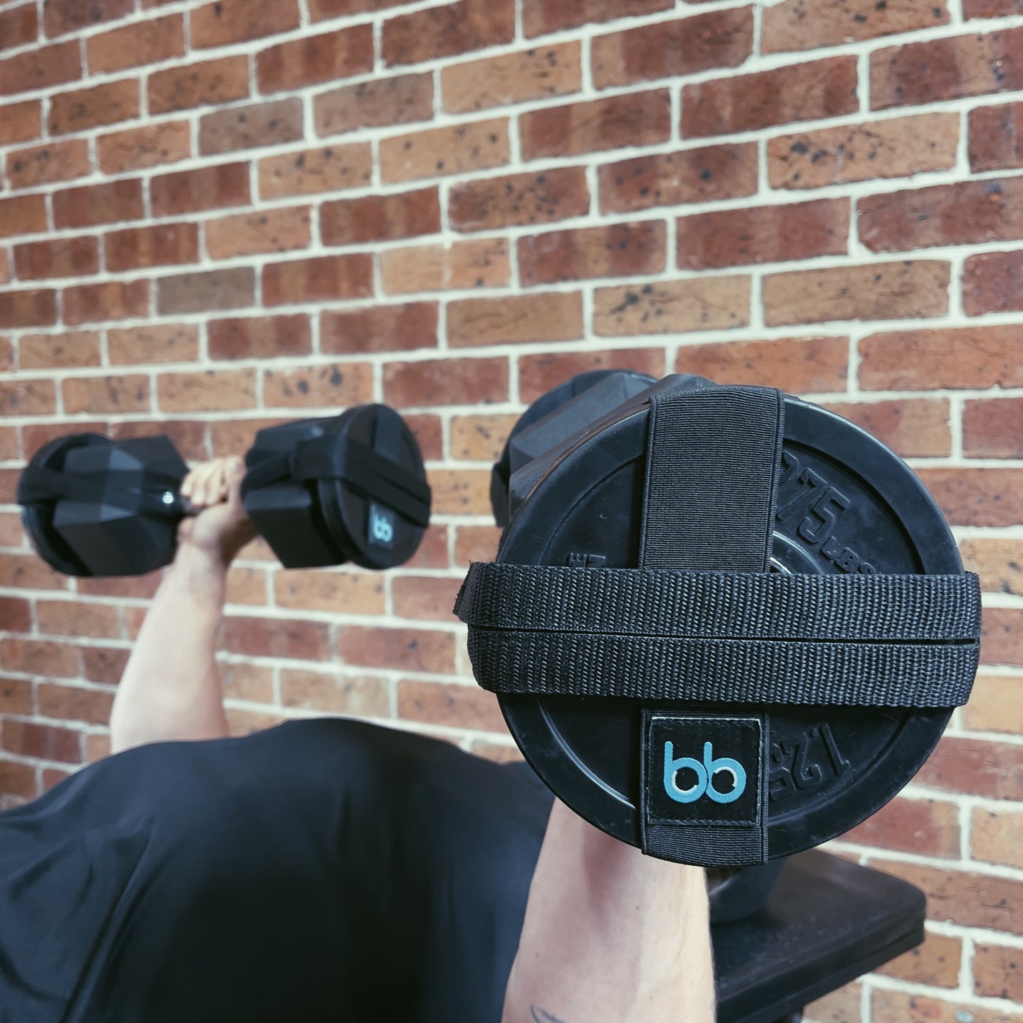 Gym goer performing incline bench press in home gym. Using 20kg dumbbell and bb weight sling attachment with 1.25kg Olympic style weight plates. BB weight sling aiding in muscle growth, conditioning and strengthening at affordable prices. 